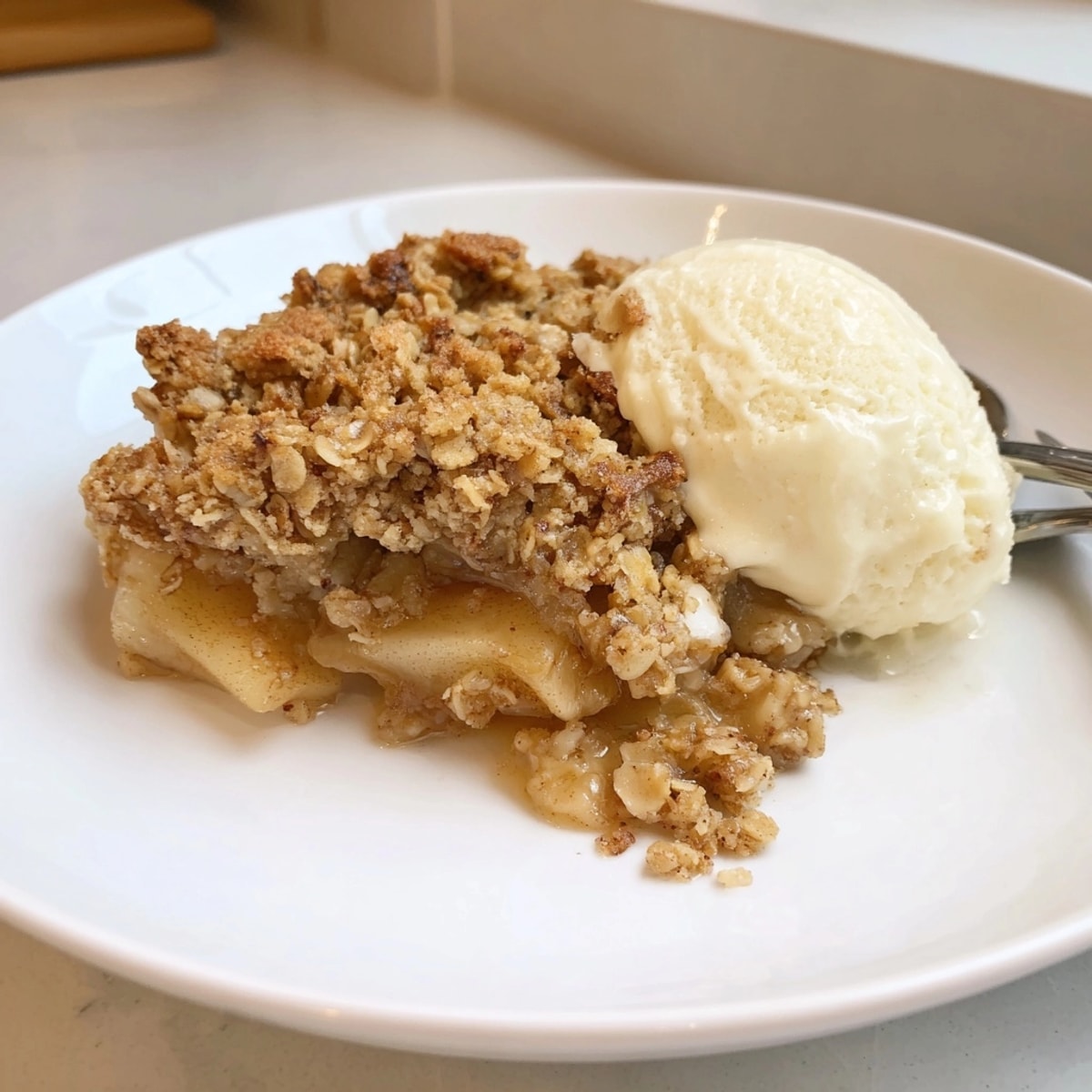 Close-up of a slice of Apple Crisp showing layer of tender apples and crunchy topping.