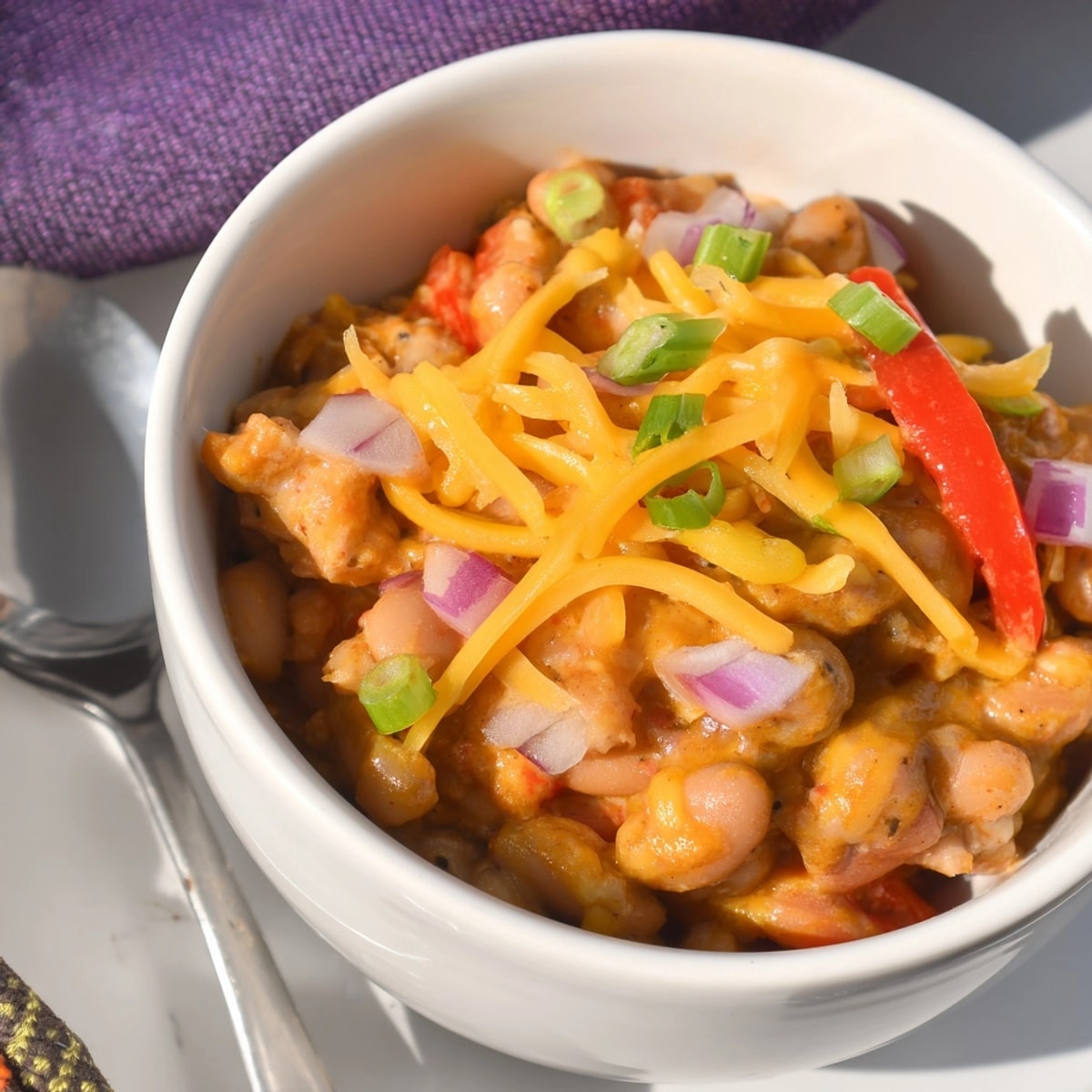 Golden, melted cheddar atop vibrant Cajun Chicken Cheddar Pintos ready to be devoured.