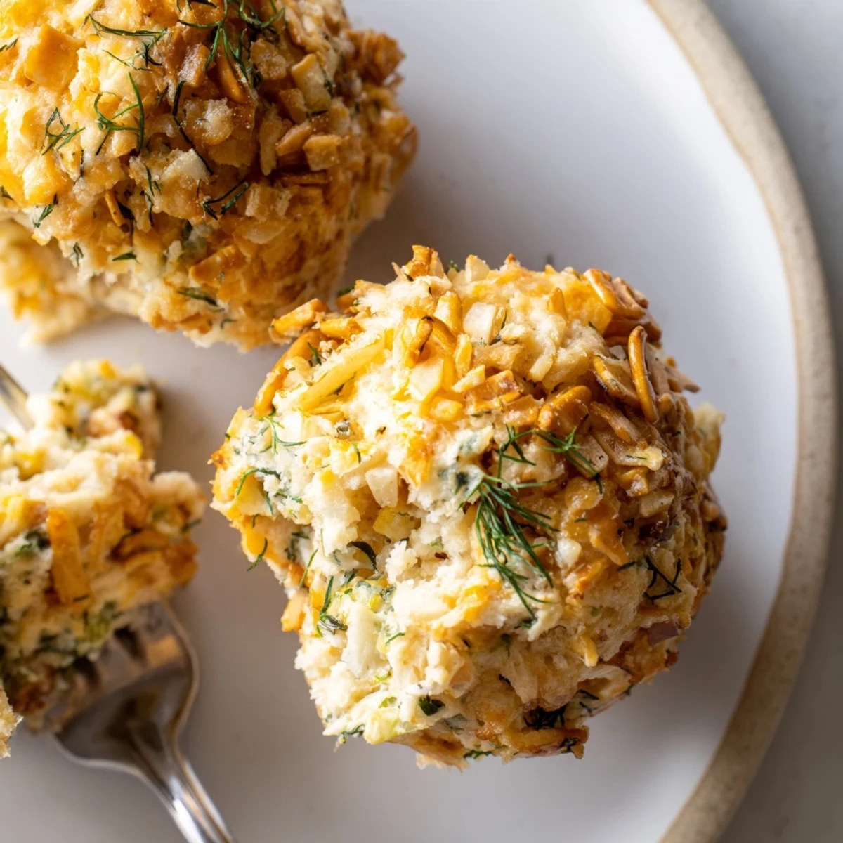 Savory dill pickle cream cheese pretzel muffins with a crunchy topping, perfect for snacking.  