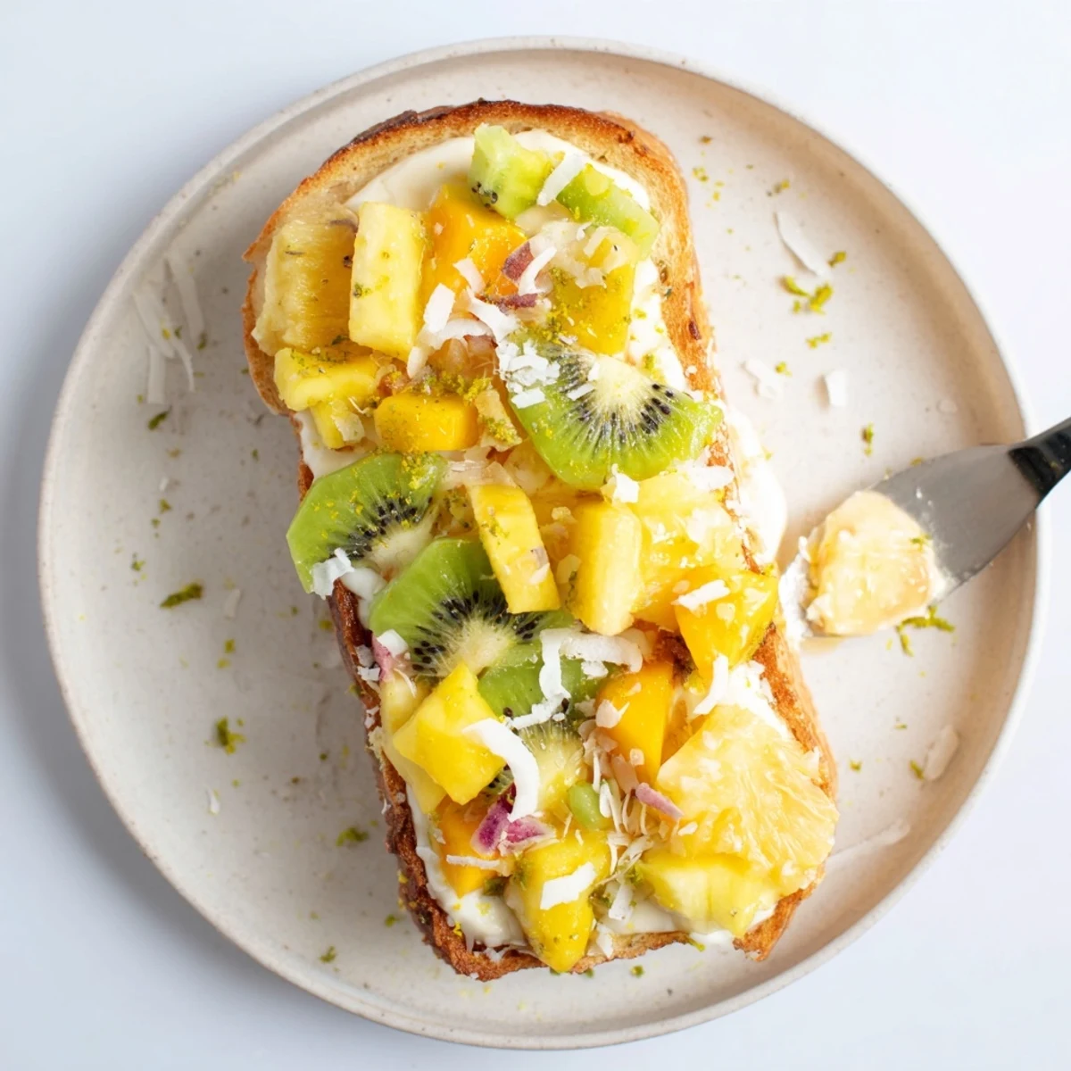 Creamy coconut yogurt custard toast drizzled with honey and tropical fruits.  