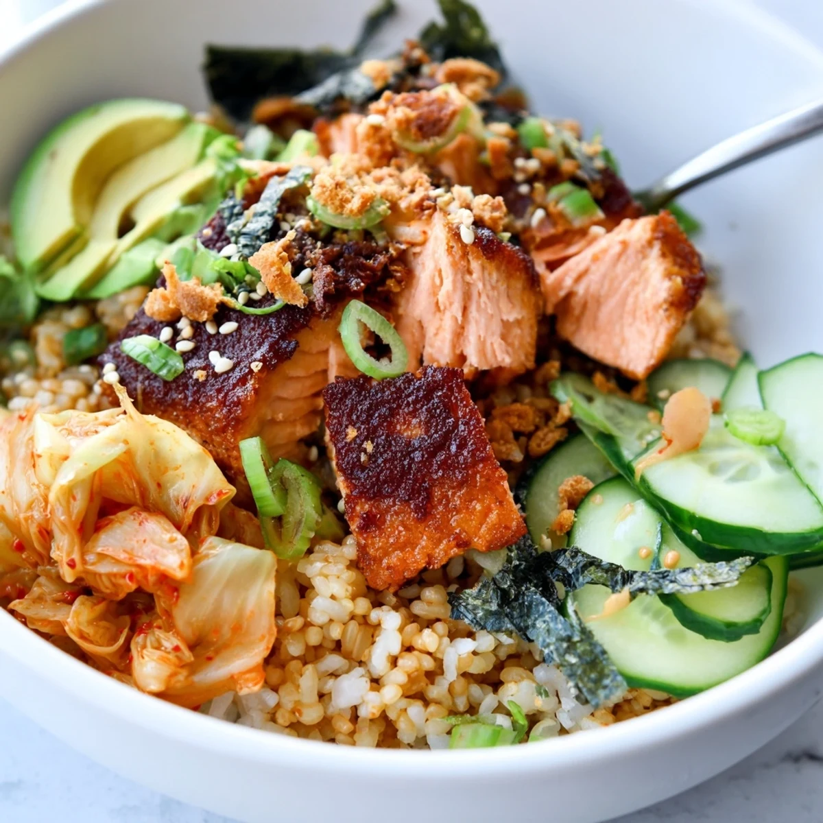 Crunchy salmon rice bowl topped with spicy mayo, fresh avocado, and kimchi.  