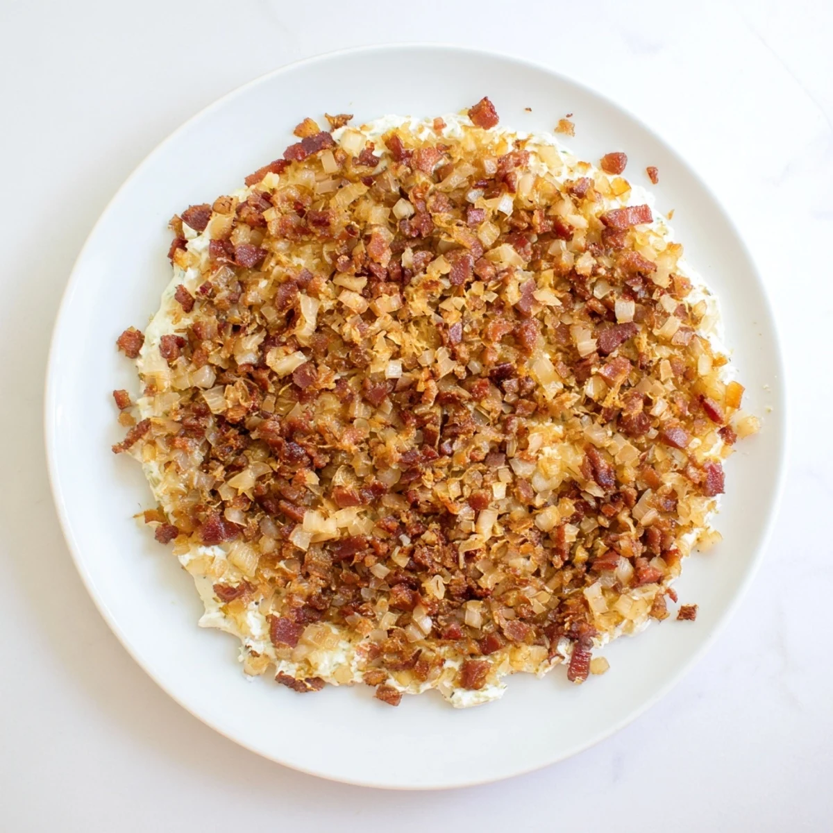 Golden caramelized onion and bacon dip, served with crispy chips, a perfect appetizer.