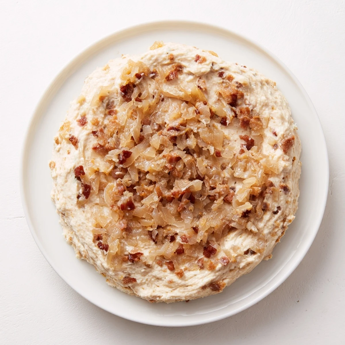 Delectable Caramelized Onion and Bacon Dip with chunks of bacon in a sour cream base, ready to enjoy.