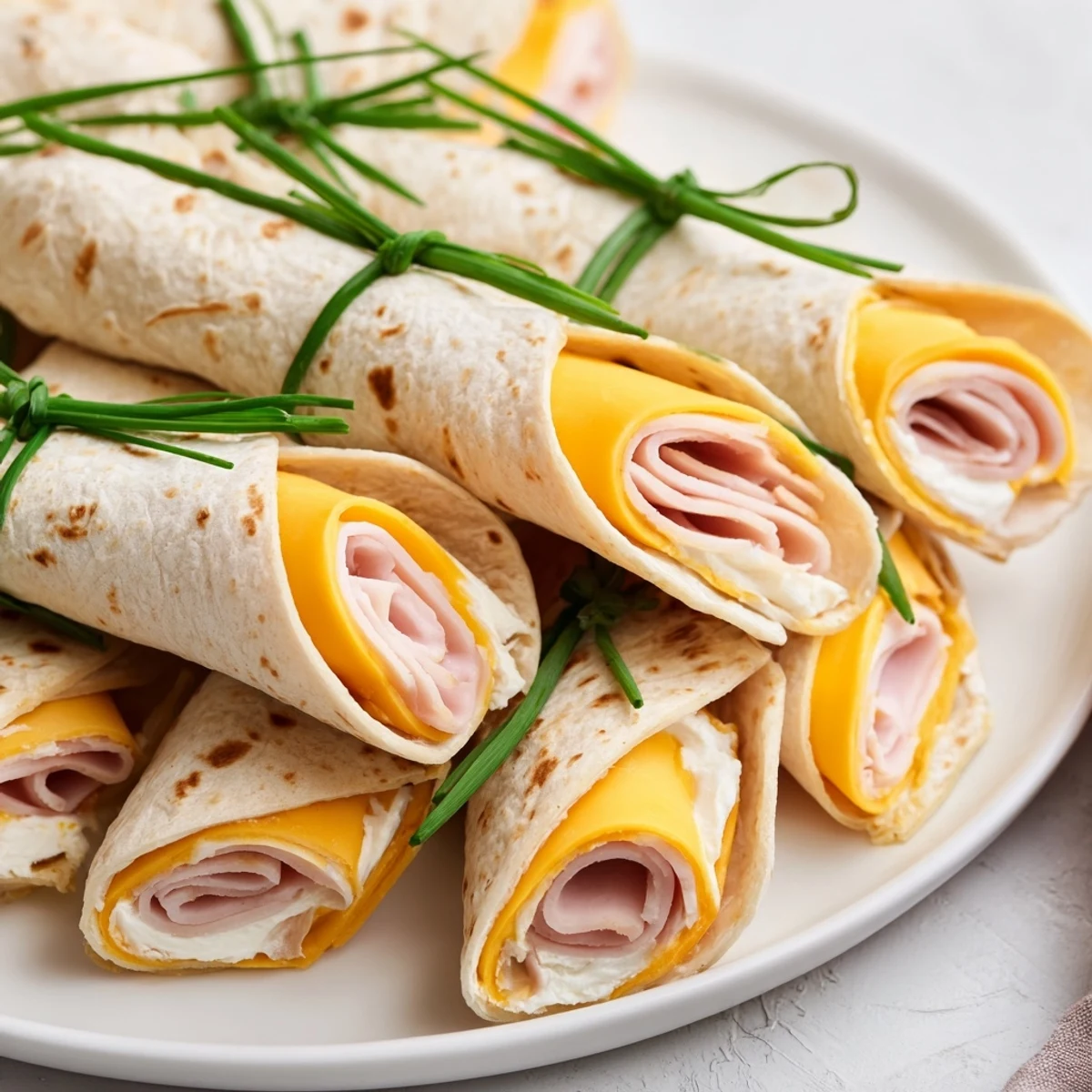 Close-up of freshly made Graduation Cap Diploma Snack Wraps featuring turkey and cheese, ready to enjoy.