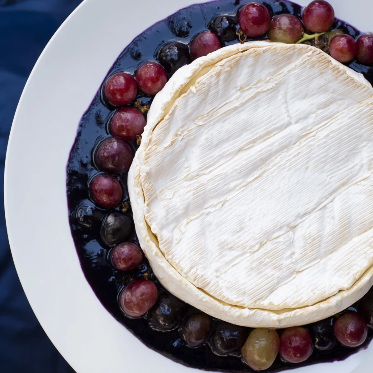 Eye-catching Floating Island: a visually stunning party platter of cheese, vibrant blue dip, and grapes.
