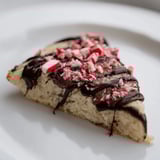 Close-up shot shows decadent Chocolate Peppermint Shortbread Wedges, drizzled with glossy chocolate topping.