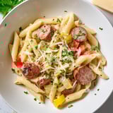 Imagine a close-up of the flavorful, bubbling Cajun Spiced Smoked Sausage Alfredo, a satisfying family meal.