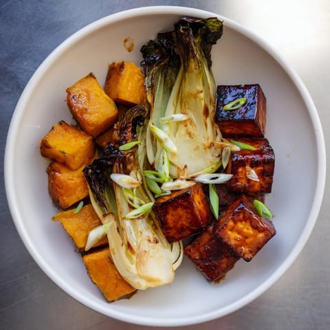 Golden-brown miso-glazed tofu and squash with vibrant bok choy, a delicious vegan dish.