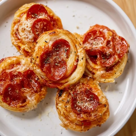 Golden, crispy Mini Pepperoni Pizza Pinwheels, a tasty appetizer filled with cheesy pepperoni goodness.