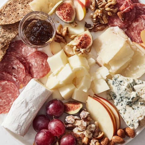 A beautifully arranged 2026 Wine Pairing Board overflowing with cheeses, meats, and fresh fruits for a tasting.