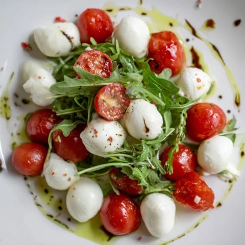 A glistening strand of mozzarella pearls adorns the fresh Pearly Strand salad, a vibrant Caprese twist.