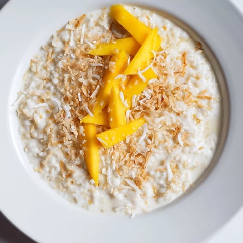 Creamy toasted coconut rice pudding, warm and comforting, topped with golden toasted coconut flakes.