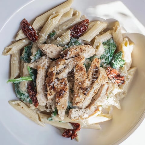 Creamy Tuscan Chicken Pasta, a vibrant dish with tender chicken atop a swirl of creamy pasta.