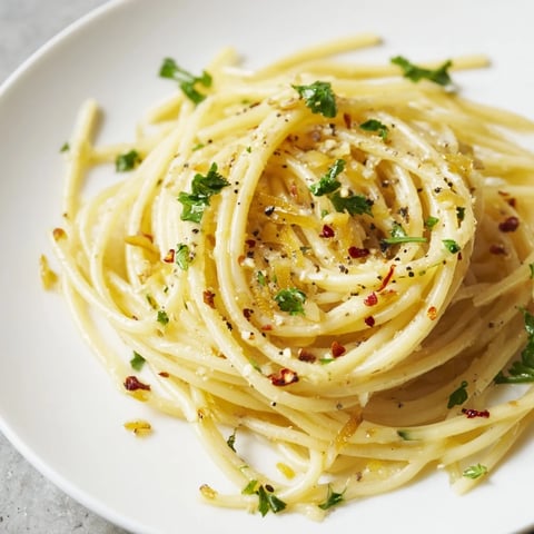 Steaming Aglio e Olio Express Pasta with glistening spaghetti and flavorful garlic oil, ready to eat.