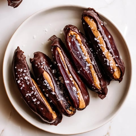 Close-up of chocolate peanut butter dates, sticky, sweet snack with sea salt sprinkles, ready to enjoy.