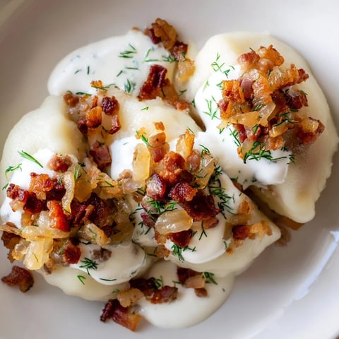 Steaming Lithuanian Cepelinai dumplings, beautifully oval-shaped, served with creamy bacon sauce.