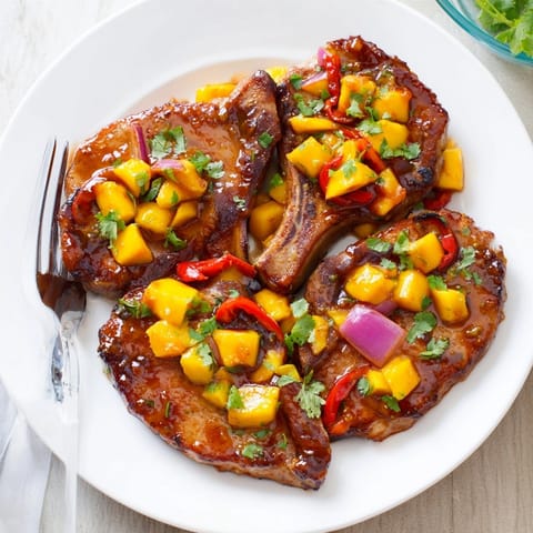 A vibrant Mango BBQ Pork Chop Bake with colorful peppers and onion slices.