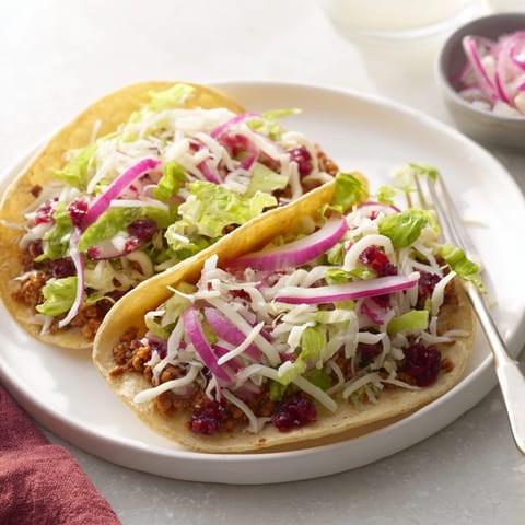 Creative tacos filled with creamy cranberry jalapeño dip and vibrant, crunchy toppings.  