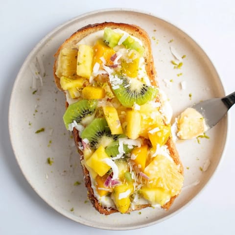 Creamy coconut yogurt custard toast drizzled with honey and tropical fruits.  