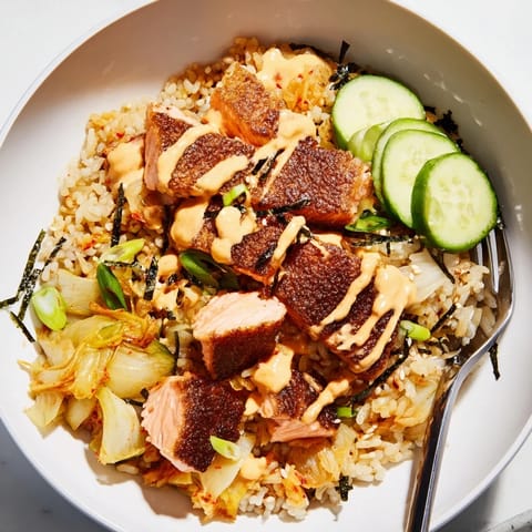 Delicious crispy salmon rice bowl featuring golden rice, spicy mayo, and garlic chips.  