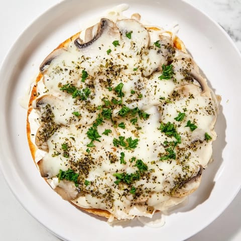 Bubbling mozzarella blankets the easy frozen pizza upgrade, featuring herbs and savory mushrooms.