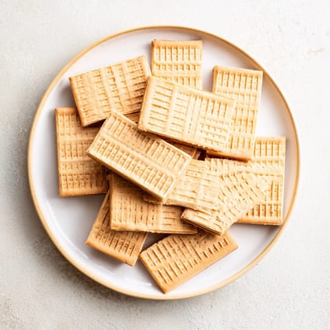 Warm, freshly baked classic shortbread cookies with a delicate, crumbly texture, perfect for sharing.
