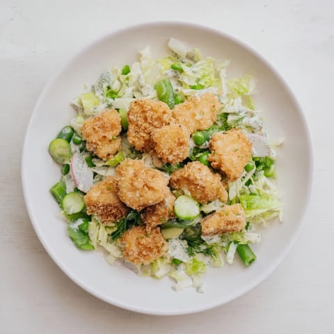 A close-up view of the fresh Green Goddess Nugget Salad, tossed in creamy green dressing.