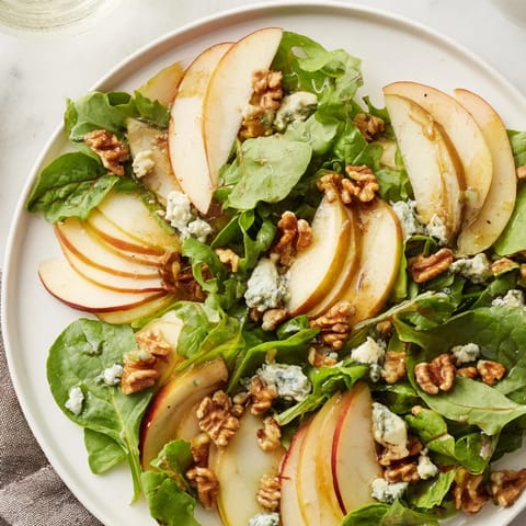 A close-up of vibrant Apple and Walnut Salad with crumbled blue cheese, celery, and a honey-Dijon dressing.  