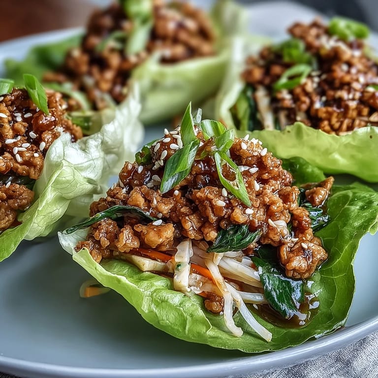 Platter of Potsticker Noodle Lettuce Cups arranged with dipping sauce, showcasing crisp butter lettuce leaves and aromatic scallion garnish.