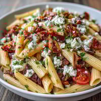 Greek Pasta Salad with Olives and Feta, a colorful medley of al dente pasta, briny Kalamata olives, and tangy feta cheese, tossed with crisp vegetables and a zesty herb dressing.